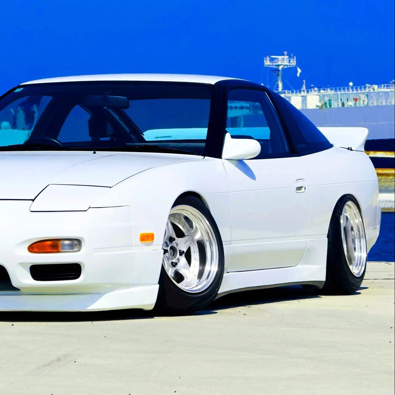 White sports car with a blue interior on a clear day