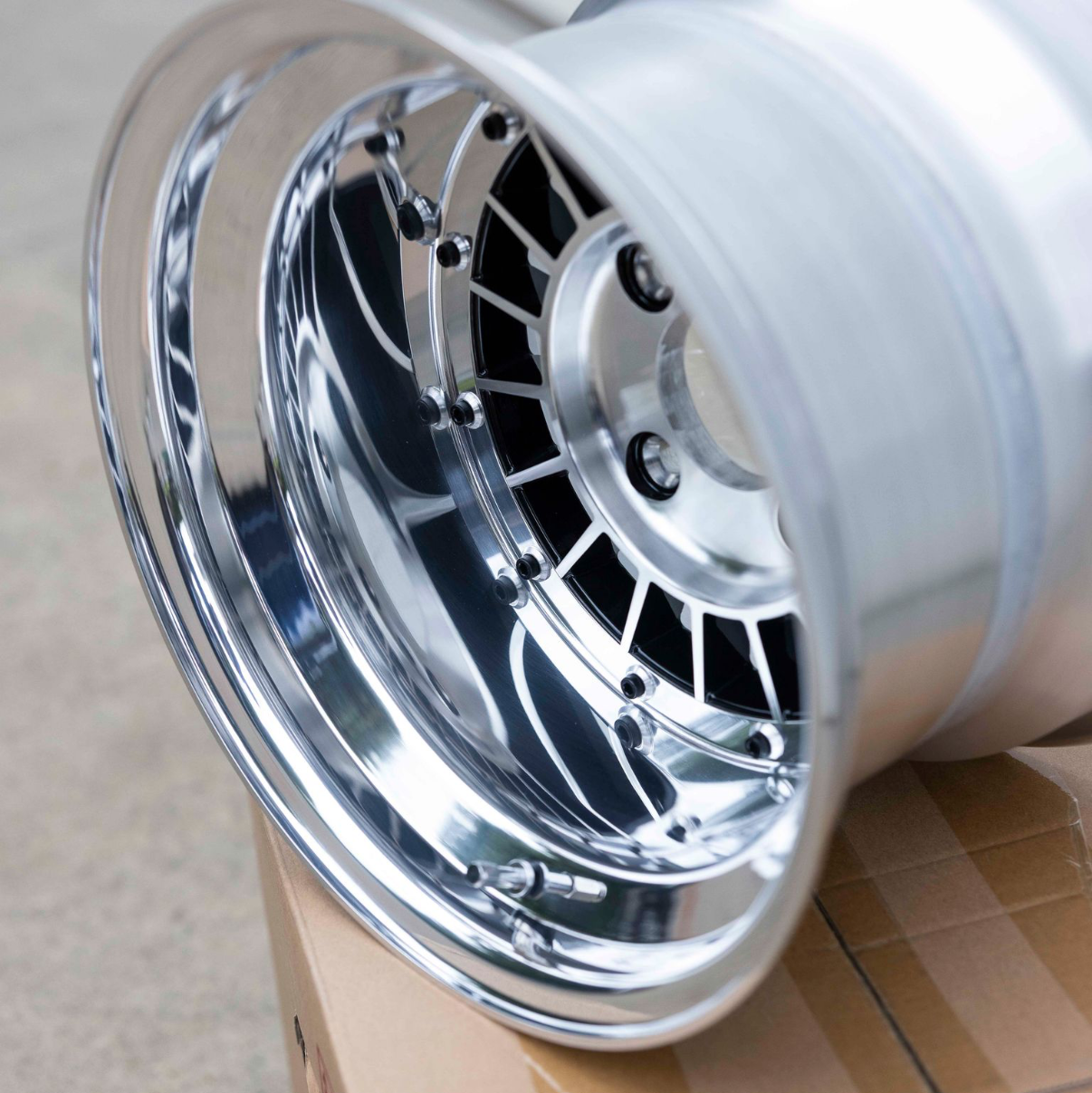 Chrome rim on a cardboard box with a plain background