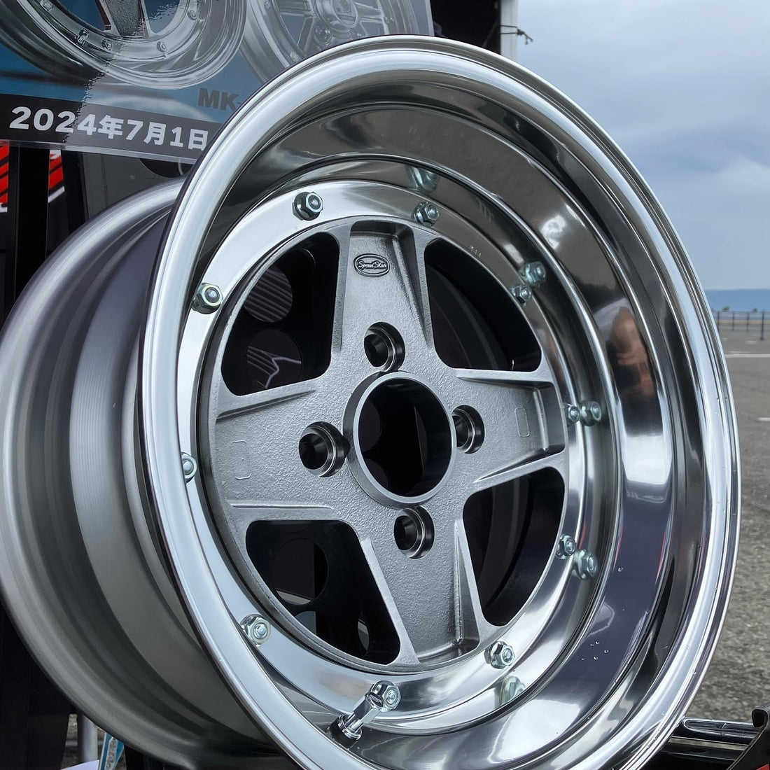 Close-up of a shiny car wheel rim with a blurred background
