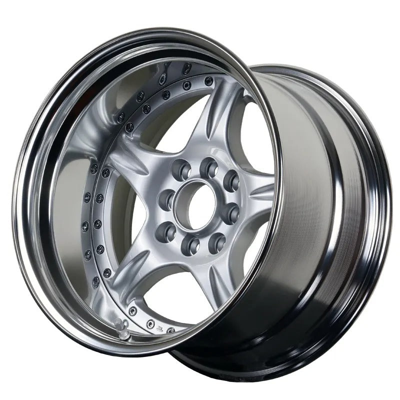 Close-up of a shiny metallic car wheel rim on a white background