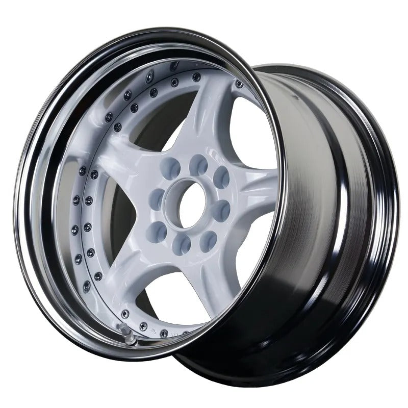 Close-up of a shiny alloy wheel with a black rim on a white background