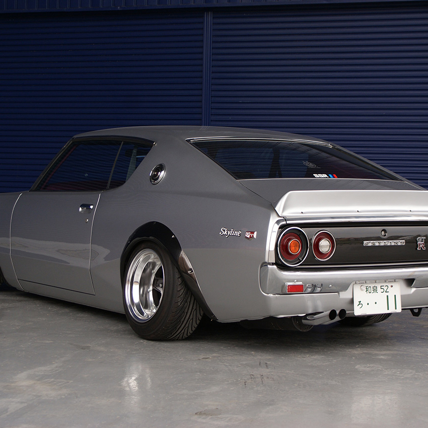 Gray sports car with 'SSR' branding on a concrete floor against a blue wall.